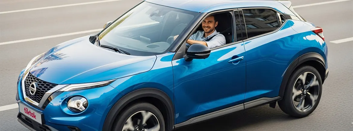 Mavi Nissan Juke model aracıyla pozitif bir şekilde poz veren sürücü, TikTak Neo araç kiralama hizmetini temsil ediyor; günlük araç ihtiyacına pratik ve esnek çözüm sunan TikTak Neo.