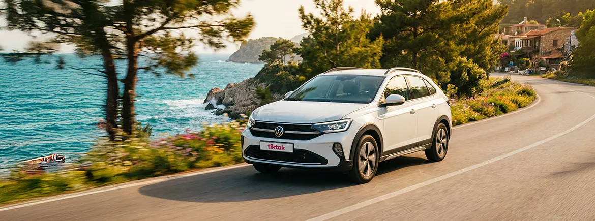 Yazlık tatil rotasında sahil yolunda ilerleyen TikTak aylık kiralık araç – uzun süreli kullanımda yazlık tatillerine uygun esnek ve konforlu aylık araç kiralama seçeneği.