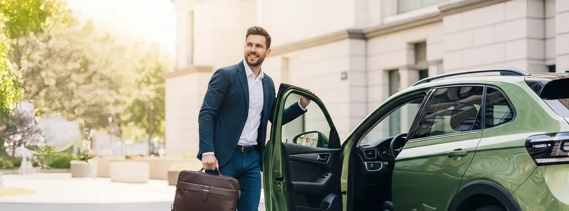 Elinde evrak çantasıyla araca binen iş insanı – 30 günlük araç kiralama ile iş seyahatlerinde esnek ve hızlı çözüm alternatifi.
