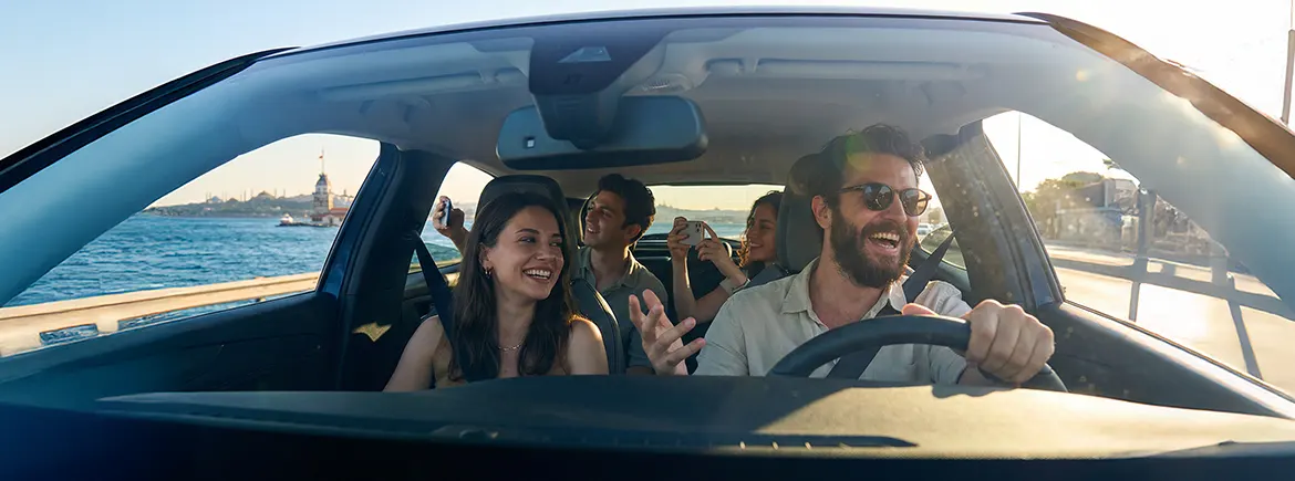İstanbul sahil yolunda Kız Kulesi manzarası eşliğinde misafirlerini gezdiren neşeli sürücü ve şehir turları için ideal TikTak ile günlük araç kiralama konforu.