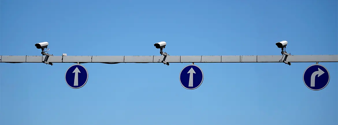 Trafik akışını ve kuralları denetleyen tepe kameraları ile yön tabelaları altında, kiralık araç kullanıcıları için tiktak trafik cezası ve tiktak hgs süreçlerinin işleyişi.