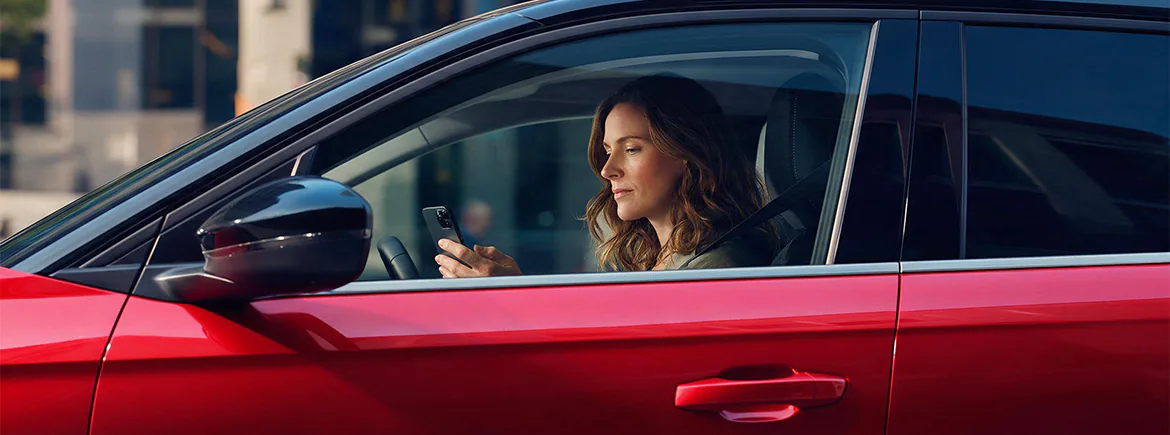Kiralık TikTak aracında telefonuna bakan kadın sürücü